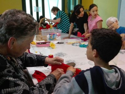 Infància i gent gran s’apropen en el taller intergeneracional de roses de Sant Jordi 