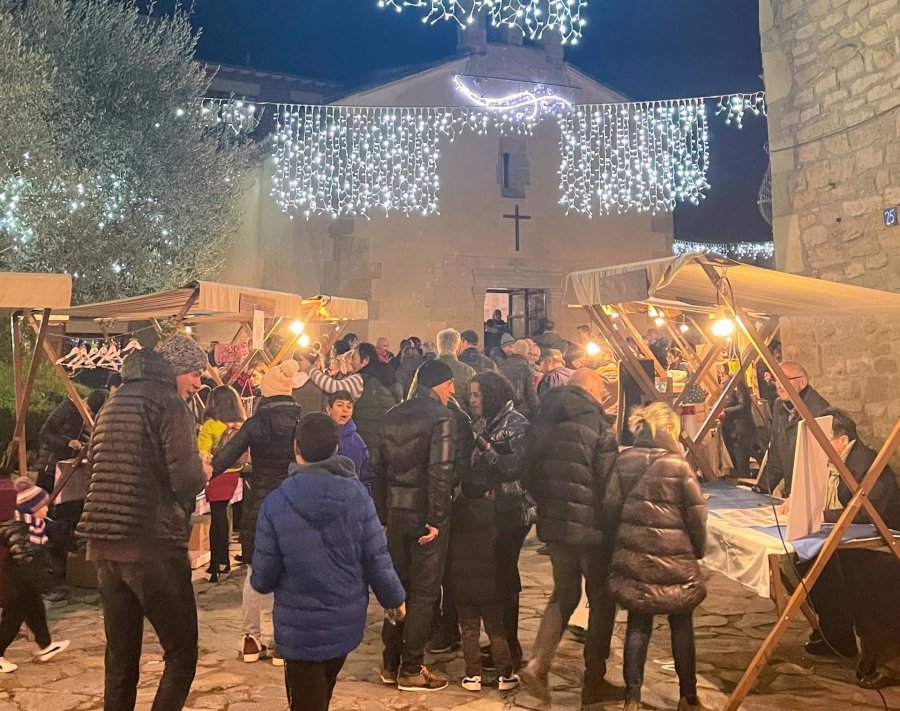 Fira de Santa Llúcia — 2022 — Parades de nadal amb la capella al fons, llums de nadal i gent passejant