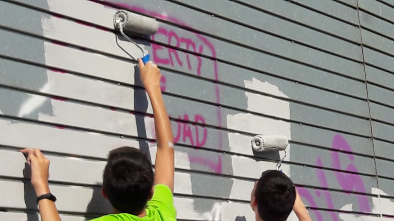 Joves de pintant pintant un mural a la paret del Pipican