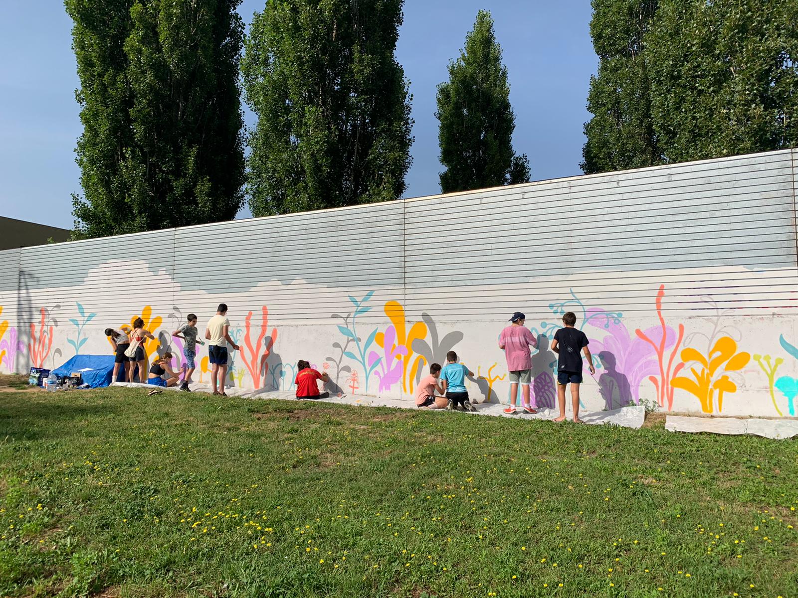 Joves de pintant pintant un mural a la paret del Pipican